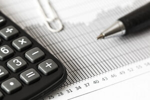 cómo obtener financiamiento, una calculadora, pluma y plan de negocios